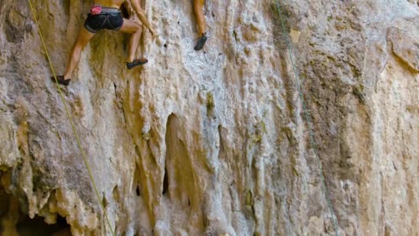 Grupo de turistas intentando escalar la cara vertical de un marinero en Railay Beach en Tailandia . — Vídeo de stock