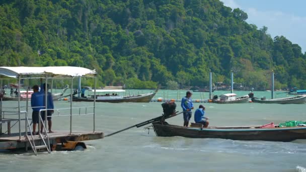 浅い海にトレーラーをプッシュ トラクターです。手づくりから貨物を収集します。タイのライレイビーチで木製の遊覧船. — ストック動画