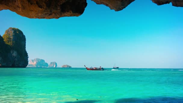 Handcrafted. Wooden Boat Passing a Cave on the Tropical Sea — Stock Video