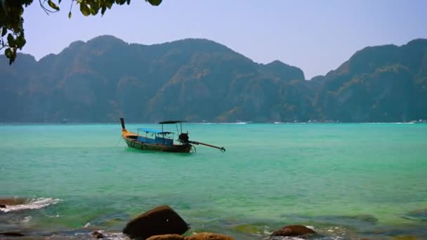 Сделано вручную. Деревянный. Longtail Boat at at Anchor near a Tropical Beach — стоковое видео