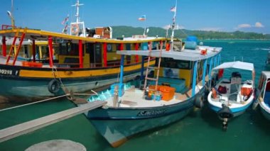 Bir iskele ve Kota Kinabalu bekleyen turist renkli yolcu tekneler yanaştı. Malezya