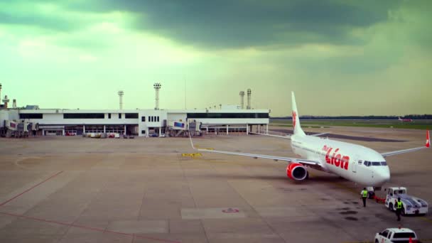 Tow trekker duwt terug Thaise Lion Airliner op Don Mueang International Airport in Bangkok. Thailand — Stockvideo