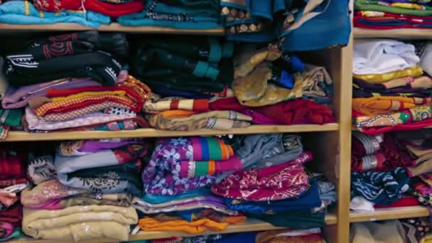 Kleidung im indischen Stil. zusammengefaltet auf Regalen in einem Geschäft — Stockvideo