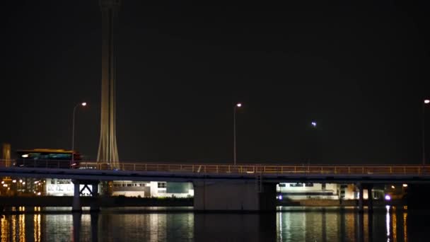 Trafik korsar en upptagen bro på natten under Macau Tower — Stockvideo