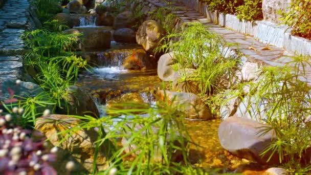 El agua cae juguetonamente sobre una cascada de ingeniería — Vídeo de stock