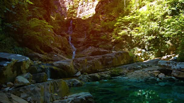Smalle natuurlijke waterval meanderende naar beneden rotsachtige baan — Stockvideo