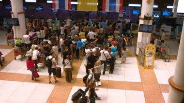 Tayland Phuket Uluslararası Havaalanı'nda Air Asia kalkış check-in kontuarında sırada bekleyen yolcuların çekim bakan.