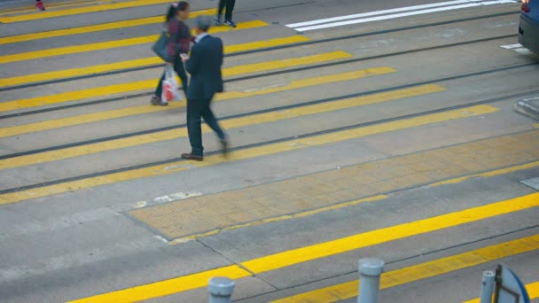 Pedestrians crossing a busy city street at a safety crosswalk in downtown Hong Kong. — Stock Video