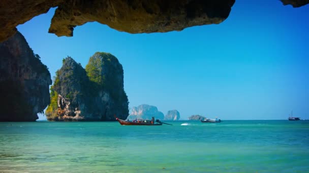 Лонгтейл човни проходить величезні скелі Рейлі-Біч в Таїланді. — стокове відео
