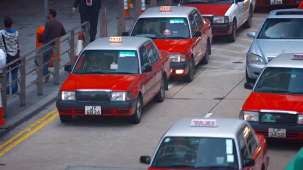 Hong Kong şehir merkezinde işlek bir kentsel sokakta taksi ve diğer araç trafiği — Stok video