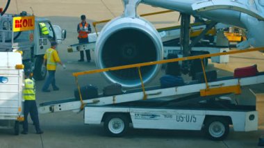 Yer destek personeli ticari bir yolcu uçağından bagaj boşaltma