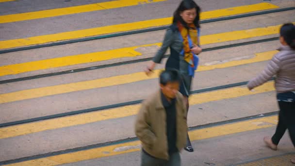 Voetgangers oversteken een drukke stedelijke straat in het centrum van Hong Kong — Stockvideo