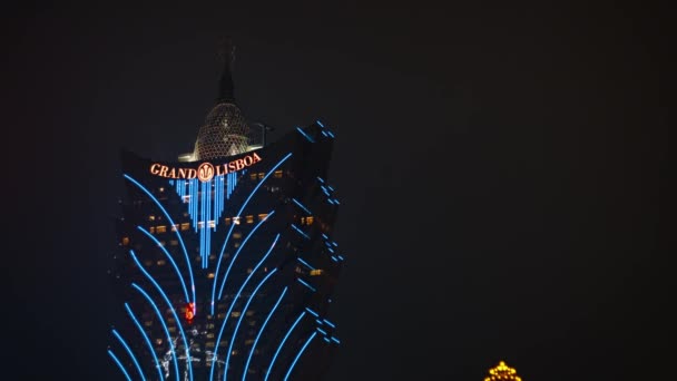 Fel verlicht Grand Lisboa casino. vervagen van focus tegen een nachtelijke hemel — Stockvideo