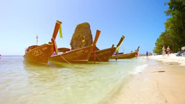 観光客は、タイの穏やかな波でボート ボブとしてライレイ ビーチに沿って散歩します。 — ストック動画