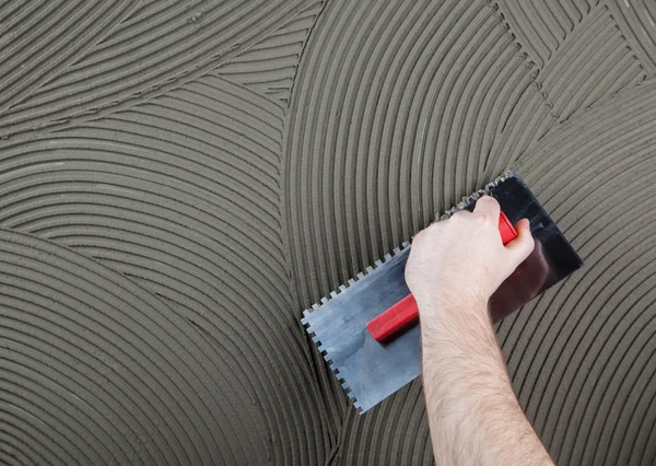 işçi tutkal bir döşeme için bir duvar üzerinde geçerlidir. 