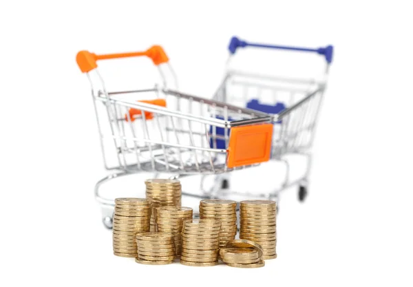 Coins in a column on the background shopping carts. focus on coi — Stock Photo, Image