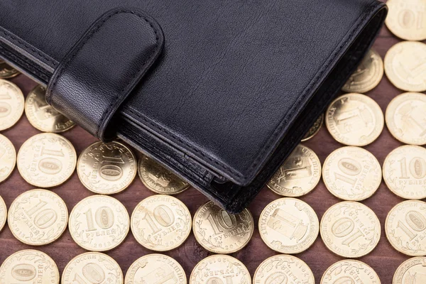 Black leather wallet on golden coin — Stock Photo, Image