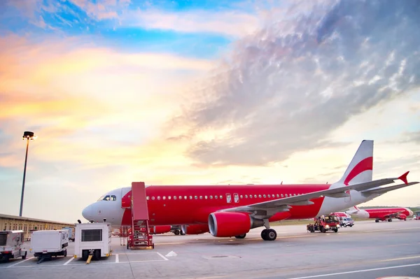 Vliegtuigen op luchthaven in kleurrijke sunrise. — Stockfoto