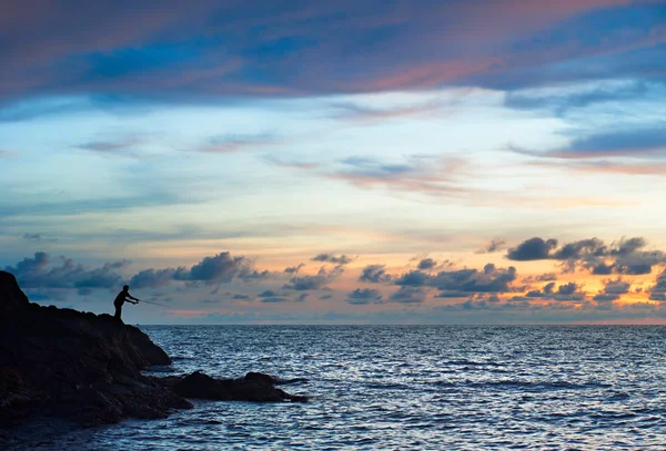 Silhouette of a fisher  on  cliff — Stock Photo, Image