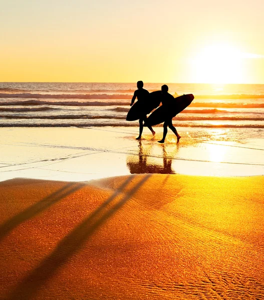 Silhouettes of surfers on beach — Stock Photo, Image