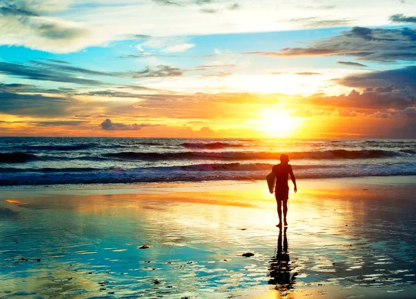 Surfer wandelen op het strand in zonsondergang — Stockfoto