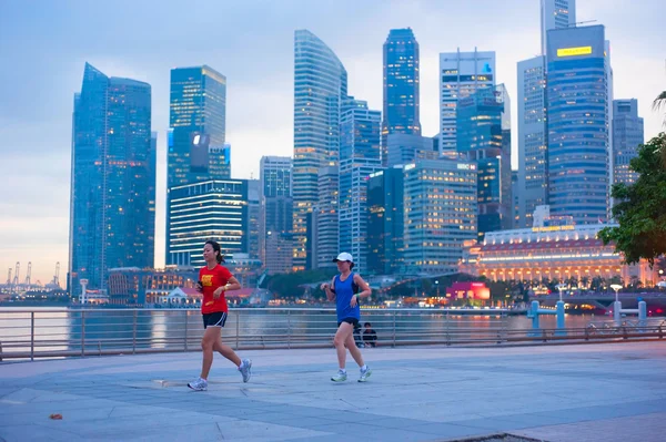 People runnig in front of Singapore downtown — Stock fotografie