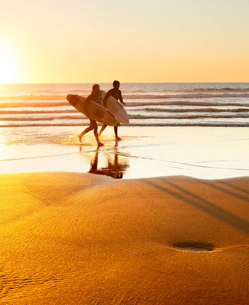 Due surfisti che corrono sulla spiaggia — Foto Stock