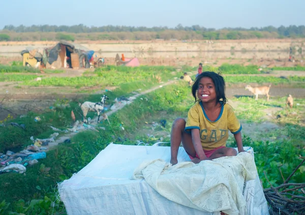 デリー インド 2012 笑顔の背景にヤギと屋外に座っている哀れな少女 — ストック写真