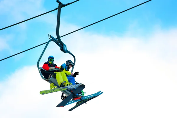 Skifahrer und Snowboarder am Skilift — Stockfoto