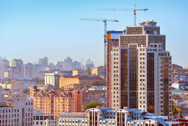 Construction cranes and modern skyscraper — Stock Photo, Image