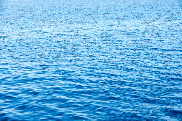 Blaues Wasser mit Sonnenreflexen — Stockfoto