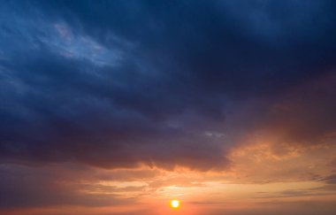 Güneş ışınlarıyla gün batımı, bulutlarla gökyüzü ve güneş.