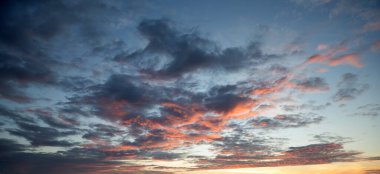 Güneş ışınlarıyla gün batımı, bulutlarla gökyüzü ve güneş.