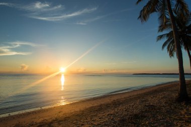 Tropikal adada okyanusun üzerinde renkli gün batımı