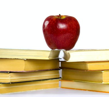 Kırmızı elma ve bir yığın kitap.