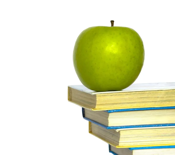 Зеленое яблоко и книги — стоковое фото