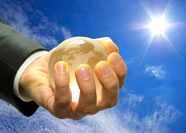 Globe in hand isplated on sky — Stock Photo, Image