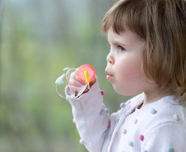 Child girl blowing soap bubbles — Stock Photo, Image