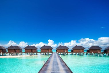 Güzel sahil. Tropik plaj. Tatil ve tatil konsepti. Kum, mavi deniz suyu, turkuaz okyanus, güneş gökyüzü beyaz bulutlar.