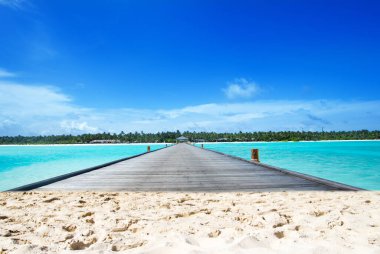 Güzel sahil. Tropik plaj. Tatil ve tatil konsepti. Kum, mavi deniz suyu, turkuaz okyanus, güneş gökyüzü beyaz bulutlar.