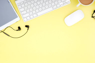 tablet, klavye, kahve fincanı ve gözlük ile çalışma alanı alanı Sarı zemin üzerine kopyalayın. Üstten Görünüm.