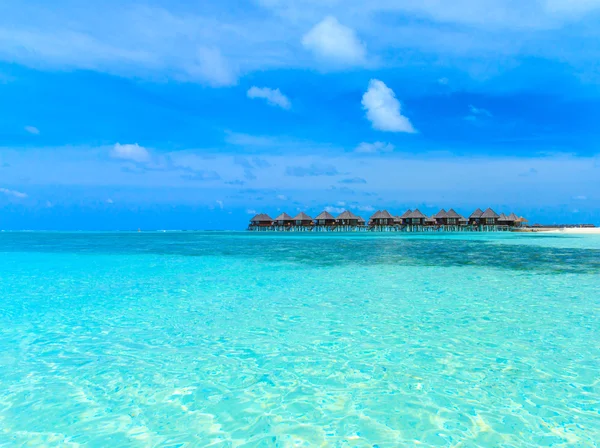 Tropical beach with bungalows — Stock Photo, Image