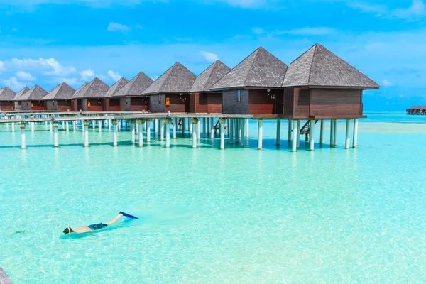 Strand med blå lagunen och bungalows — Stockfoto