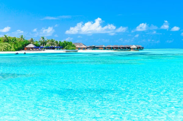 Beach with lagoon and wooden bungalows — Stock Photo, Image