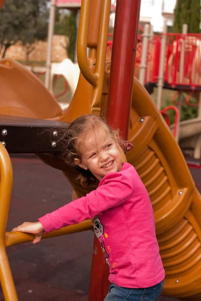 A menina bonita jogar no parque infantil — Fotografia de Stock