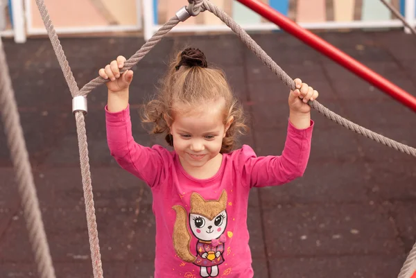 A menina bonita jogar no parque infantil — Fotografia de Stock