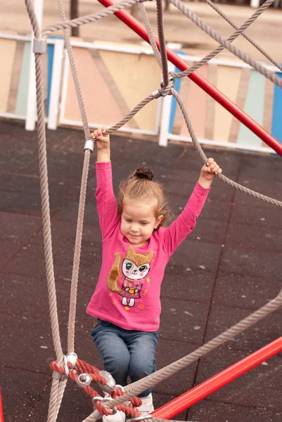 A menina bonita jogar no parque infantil — Fotografia de Stock