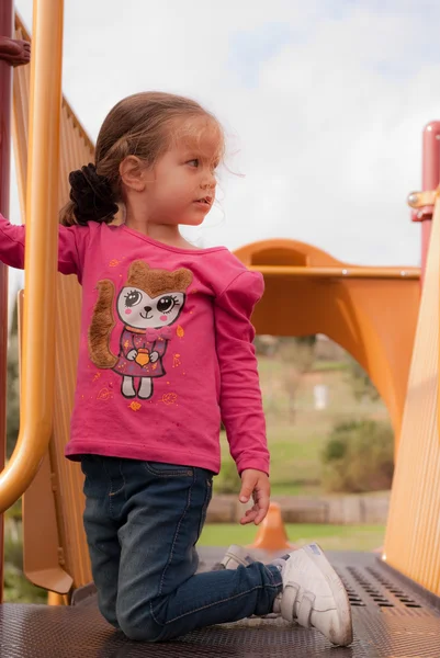 A menina bonita jogar no parque infantil — Fotografia de Stock