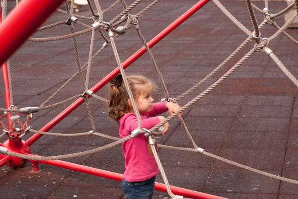 A menina bonita jogar no parque infantil — Fotografia de Stock