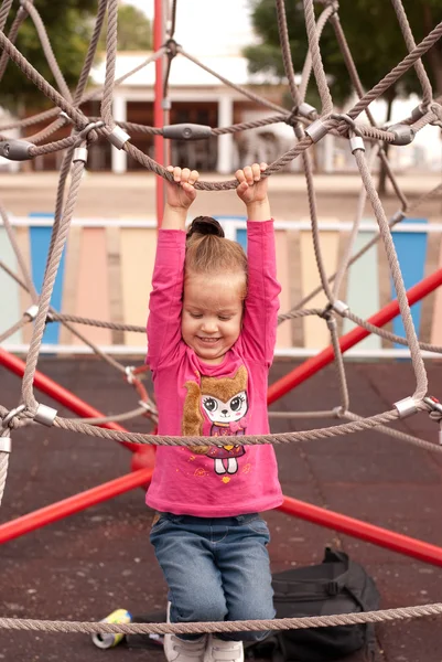 A menina bonita jogar no parque infantil — Fotografia de Stock